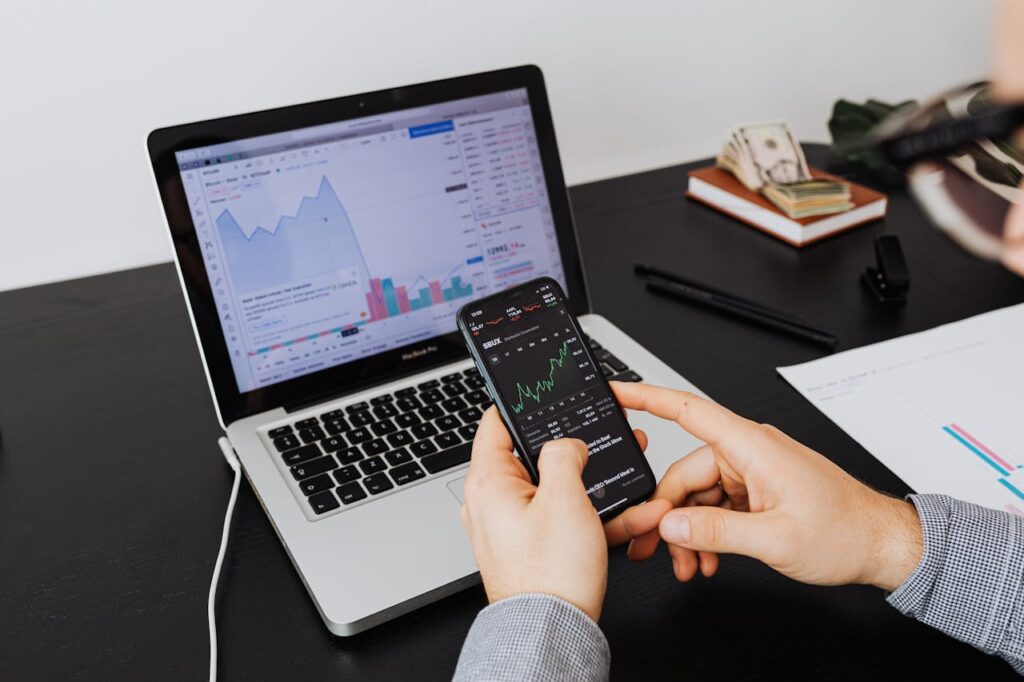 Por que seu Marketing está Falhando em 2026: 8 Verdades Incômodas Reveladas pelos Dados Person analyzing stock market data on a laptop and smartphone indoors.